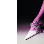 LOUIS VUITTON HAUTE JOAILLERIE :Collection Deep Time Collier « Flight » en or blanc et platine serti de diamants blancs et d’un rubis du Mozambique taille coussin de 4,17 carats, couleur « sang de pigeon ». Sandale SPORTMAX. Set design Garance Dunord.
